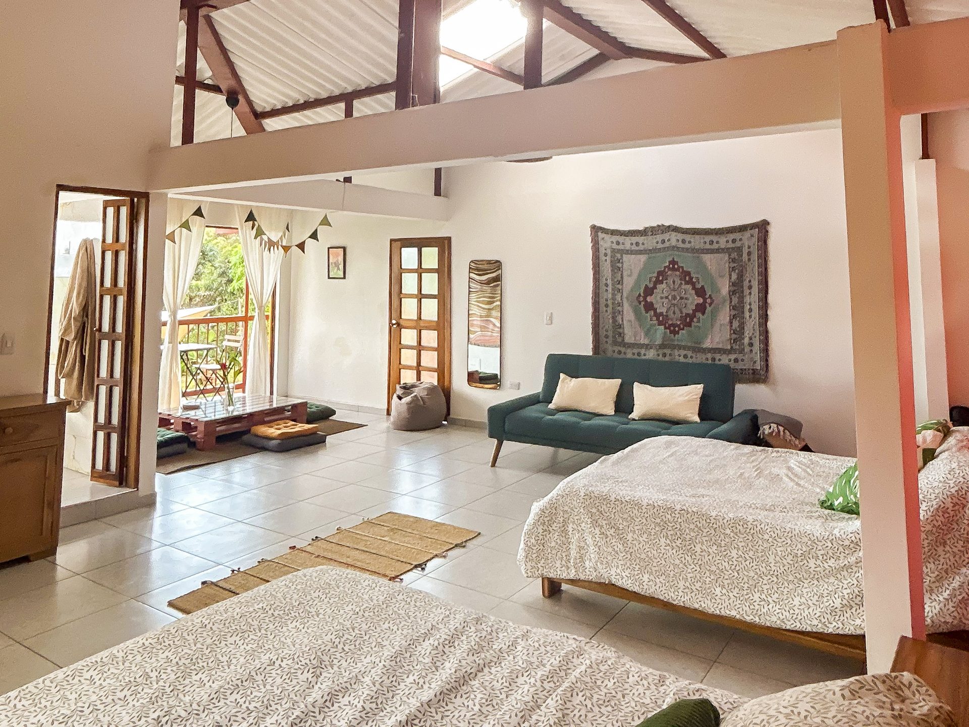 Zona de estar de la Suite King con balcón y vista al bosque en El Nido Andino