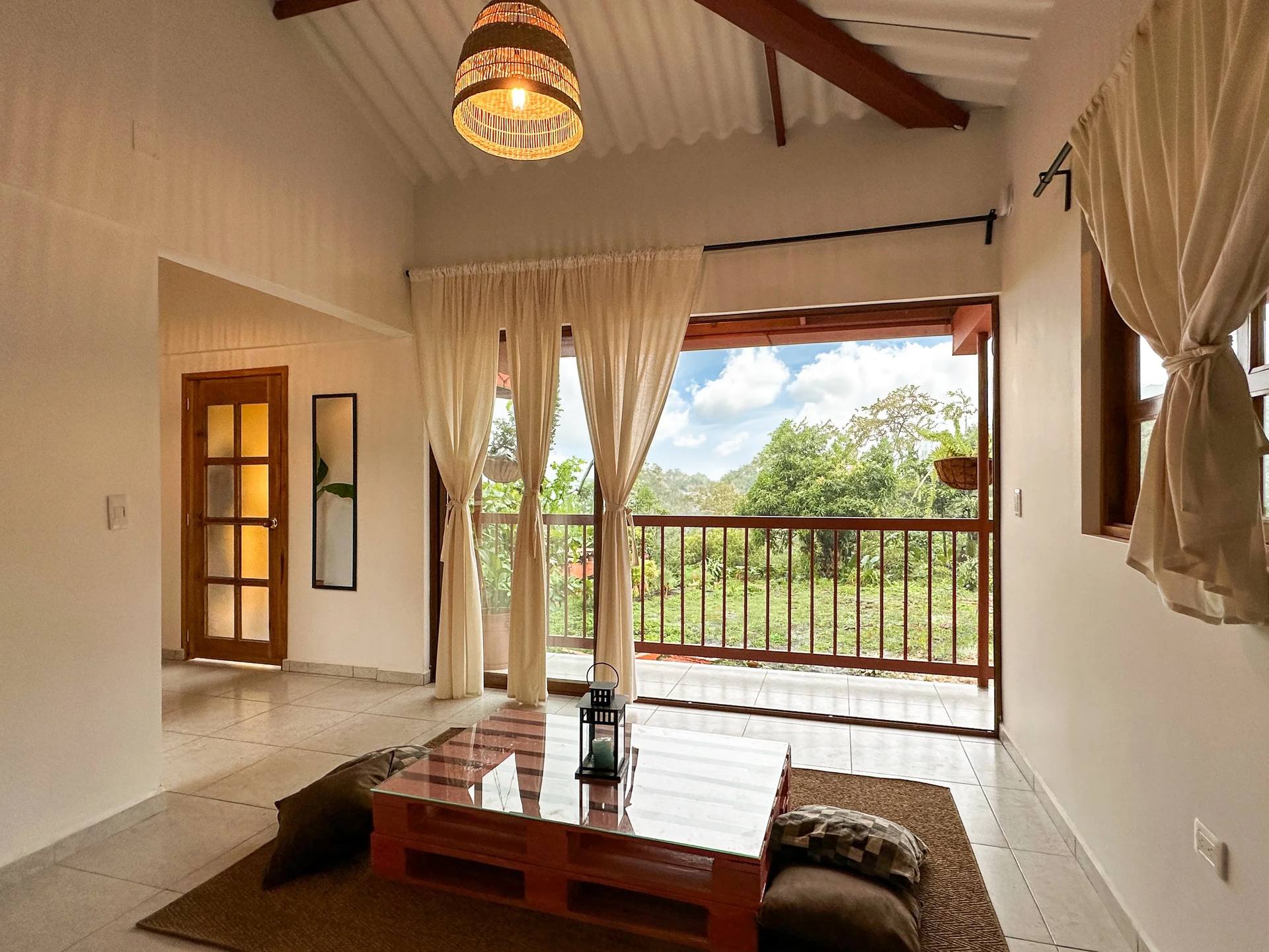 Sala de la Suite King con hamaca y puertas de balcón en El Nido Andino, La Mesa Cundinamarca
